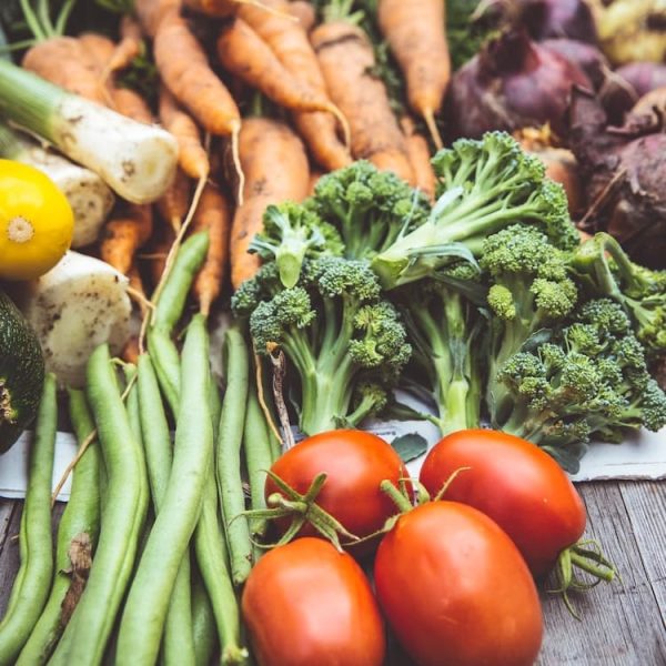 Regionale Kulinarik: Gemüse auf einem Holztisch - Tomate, Brokkoli, Zucchini, Möhre, Bohnen